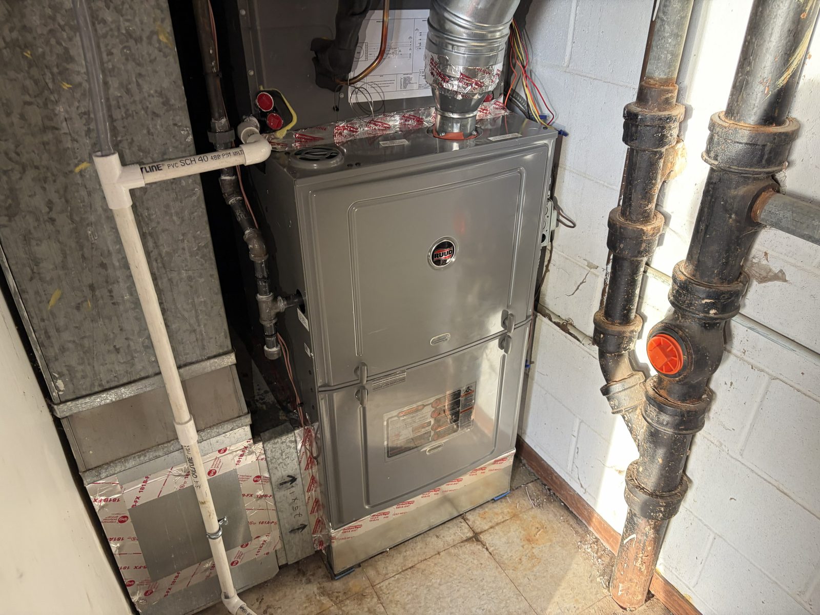 Technician servicing a gas furnace during a repair visit